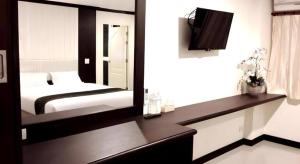 a bedroom with a bed and a television in it at The Capital Hotel in Roi Et