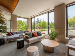 a living room with couches and tables and large windows at Tateshina Lake Resort in Tateshina +41 photos