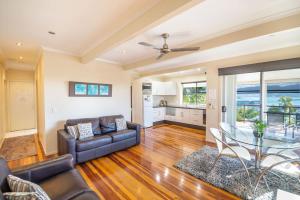 a living room with a couch and a glass table at Airlie Apartments in Airlie Beach