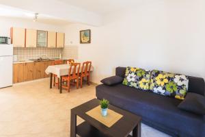 ein Wohnzimmer mit einer blauen Couch und eine Küche in der Unterkunft Apartments Dalia in Vis