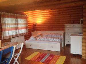 ein Schlafzimmer mit einem Bett und einer Holzwand in der Unterkunft Gemütliche Blockhütte in Wiennähe in Zöfing