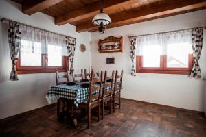 a dining room with a table and chairs and windows at Chata nad Briežkami in Raková