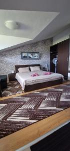 a bedroom with a large bed and a brick wall at Aspen golf studio B402 in Razlog