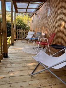 a patio with chairs and a table on a deck at O'BARA Lodge - Tiny House - Jardin et climatisation in Druillat +22 photos