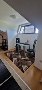 a dining room with a table and chairs on a rug at Aspen golf studio B402 in Razlog