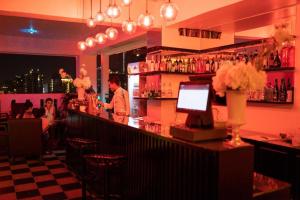 a bar with a man standing at a counter at Wind Holiday Hotel in Phnom Penh