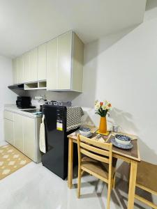 a kitchen with a table and a black refrigerator at The Tranquil Nook in Mandaue City