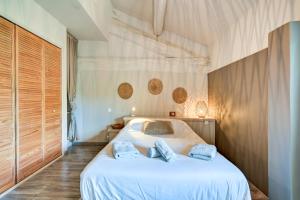 a bedroom with a bed with two pillows on it at La Pause Camarguaise in Saint-Laurent-dʼAigouze +15 photos
