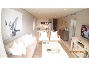 a living room with a white couch and a table at Zimbali Suite 104 in Ballito