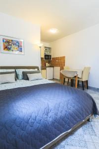ein großes blaues Bett in einem Zimmer mit Küche in der Unterkunft Apartments Dalia in Vis