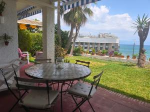 a table and chairs on a patio with a view of the ocean at Calma Bungalow 54b en Urbanización La Roca in Torremolinos