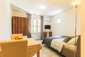 ein Schlafzimmer mit einem Bett, einem Tisch und einem Stuhl in der Unterkunft Apartments Dalia in Vis