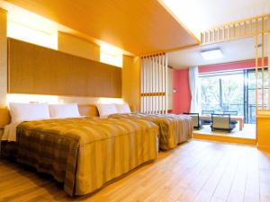 a hotel room with two beds and a large window at Izukogen Hotel Itsutsuboshi in Ito