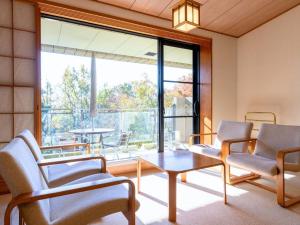 a living room with chairs and a table and a large window at Izukogen Hotel Itsutsuboshi in Ito +189 photos