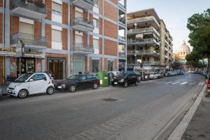 een straat met auto's aan de kant van de weg bij House Gregorio in Rome