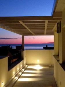 a balcony with a view of the ocean at sunset at Hotel C'era Una Volta in Castiglione della Pescaia