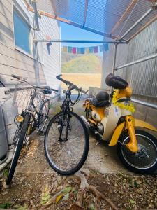 two bikes are parked next to a building at Guest House Rakufu in Anan