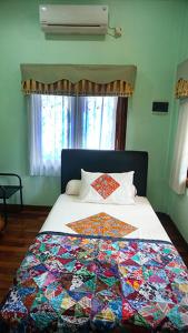 a bedroom with a bed with a colorful quilt on it at Devega Homestay in Yogyakarta