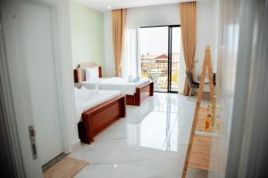 a hotel room with two beds and a balcony at Soksan Nylen Hotel in Kampong Cham