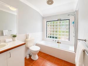 a bathroom with a toilet and a tub and a window at Longer Days at Halcyon Daze in Dunsborough +21 photos