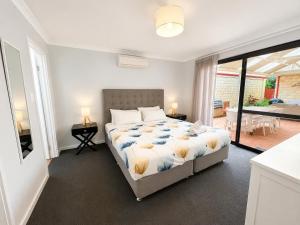 a bedroom with a bed and a view of a patio at Longer Days at Halcyon Daze in Dunsborough
