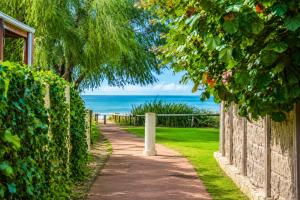 a walkway next to a fence and the ocean at Longer Days at Halcyon Daze in Dunsborough