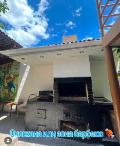 a patio with an outdoor oven with a blue sky at Green House in Cholpon-Ata