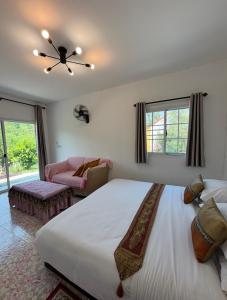 a bedroom with a large bed with a ceiling fan at ฮิมฝาย โฮมสเตย์ บึงกาฬ in Ban Nong Khang Kha