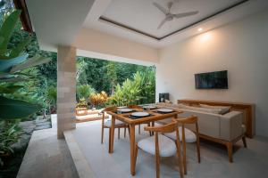 a living room with a table and a couch at River Temple Villa in Ubud