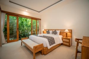 a bedroom with a bed and a large window at River Temple Villa in Ubud +70 photos