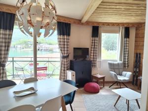 a living room with a table and chairs and a large window at Appartement 202 Geroli Lac d'Annecy in Duingt +41 photos