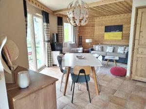 a living room with a white table and chairs at Appartement 202 Geroli Lac d'Annecy in Duingt