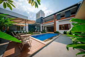 a house with a swimming pool in front of it at Bhumi Nawasena in Semalen