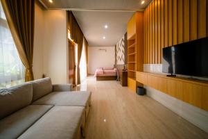 a living room with a couch and a flat screen tv at Bhumi Nawasena in Semalen