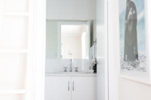 a white bathroom with a sink and a mirror at 'The Perch' - Central location in Robe, park your car and walk to everything in Robe +39 photos