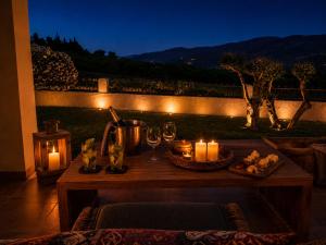 a table with candles and wine glasses on a balcony at Penelope Dream Pool Villa in Minia