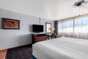 a hotel room with a bed and a flat screen tv at La Posada Lodge & Casitas, an Ascend Collection Hotel in Tucson