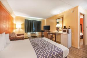 a hotel room with a large bed and a desk at Econo Lodge Inn & Suites Windsor Locks Bradley Airport in Windsor Locks