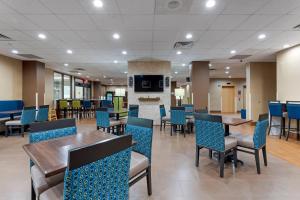 a dining room with tables and chairs and a fireplace at Comfort Inn Binghamton I-81 in Binghamton