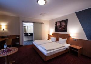 a hotel room with a bed and a table at Hotel-Restaurant Fröhlich in Kaiserslautern +41 photos