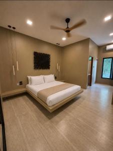 a bedroom with a large bed and a ceiling fan at Secret Cottages Chaweng Noi in Koh Samui