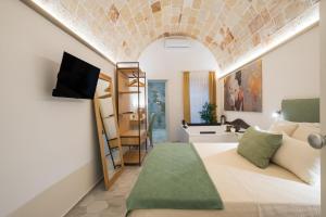 a room with a bed and a tv on a wall at Celine Dimora e Suite in Copertino