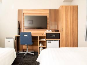 a bedroom with a desk with a television and a chair at Comfort Hotel ERA Tokyo Higashi Kanda in Tokyo +43 photos