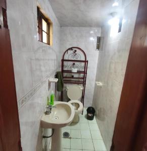 a white bathroom with a sink and a toilet at Alojamiento Casa Chuy in Jicolapa +10 photos
