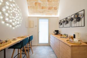 a kitchen with a bar with stools and a counter top at Celine Dimora e Suite in Copertino