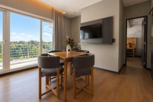 a dining room with a table and chairs and a large window at Radisson Red Funes in Rosario