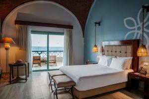a bedroom with a bed and a view of the ocean at Sentido Akassia Beach Resort in Quseir +80 photos