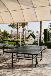 a ping pong table under a large umbrella at Sentido Akassia Beach Resort in Quseir