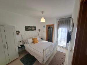 a bedroom with a white bed and a window at shohamseaview in Eilat