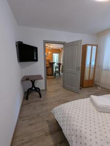 ein Schlafzimmer mit einem Bett und einem Fernseher an der Wand in der Unterkunft CasaGabri in Tarcău-Gheuca